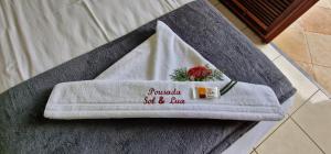 een handdoek met een bloem erop zittend op een bank bij Hotel Pousada Sol & Lua in Paracuru