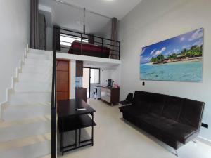 a living room with a loft bed and a staircase at GUARATUBA LOFTS in Guaratuba