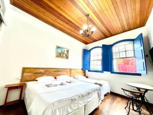 1 dormitorio con cama y techo de madera en Caminhos da Liberdade Pousada, en Ouro Preto