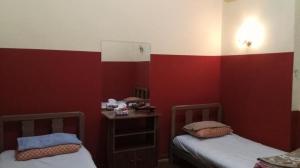 カイロにあるNew Safari Hostelの赤と白の壁の客室内のベッド2台
