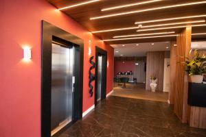 um corredor de escritório com paredes vermelhas e um corredor com um corredor em Hotel Maua em Curitiba