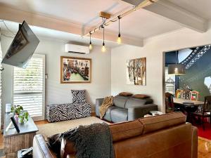 sala de estar con sofá y TV en Arthurs Seat Cottage - Sulla Collina en Arthurs Seat