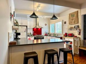 a kitchen with a large counter with stools in it at Arthurs Seat Cottage - Sulla Collina in Arthurs Seat