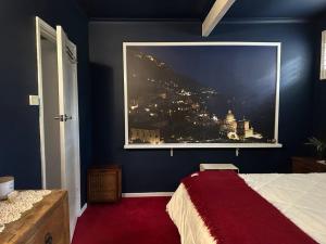 a bedroom with a large window with a view of a city at Arthurs Seat Cottage - Sulla Collina in Arthurs Seat