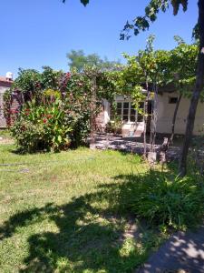 un patio con una casa con un árbol y flores en Casa céntrica El Rosal (cabaña) en San Rafael
