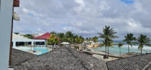 uitzicht op een resort met zwembad en strand bij Studio Lucie à MANGANAO in Saint-François