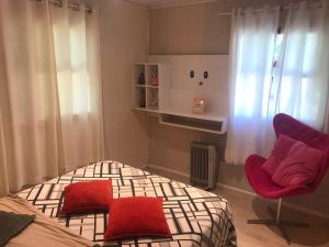 グラマドにあるCasa agradável em Gramadoのベッドと椅子のある小さな寝室