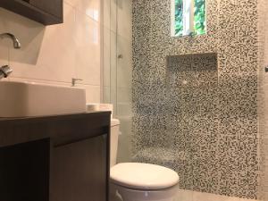 uma casa de banho com um WC, um lavatório e um chuveiro em Casa agradável em Gramado em Gramado