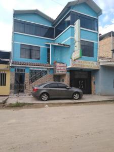 samochód zaparkowany przed niebieskim budynkiem w obiekcie ALOJAMIENTO-EDUCOL w mieście Moyobamba
