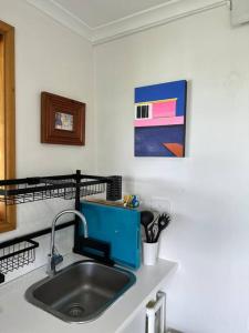 a kitchen counter with a sink and a painting at Slice of Heaven at Number 7, privacy and views in Tweed Heads