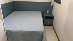 een kleine slaapkamer met een bed en een nachtkastje bij Aconchego, Ap com Piscina de Vista Panorâmica in Salvador