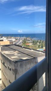 a view of the ocean from a window of a building at Aconchego, Ap com Piscina de Vista Panorâmica in Salvador