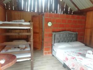 a bedroom with two bunk beds and a brick wall at Cabañas orquídea in Norcasia