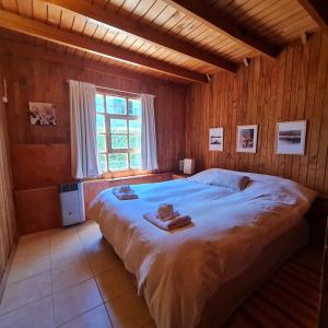 1 dormitorio con 1 cama grande y toallas. en Cabana Don Tomas - Andarlibre en San Martín de los Andes