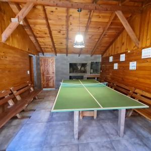 mesa de ping pong en una habitación con techos de madera en Cabana Don Tomas - Andarlibre en San Martín de los Andes