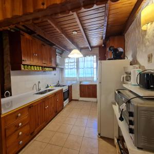 una cucina con armadi in legno e frigorifero bianco di Cabana Don Tomas - Andarlibre a San Martín de los Andes