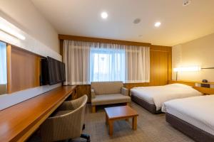 um quarto de hotel com duas camas e uma televisão em JR CLEMENT INN HIMEJI em Himeji