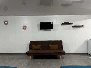 a living room with a couch and a tv on a wall at Bora Bora Hiva Home in Bora Bora