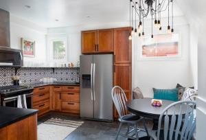 a kitchen with a table and a stainless steel refrigerator at The BARN - Washington Park, Private Guesthouse in Denver