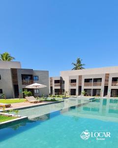 una piscina frente a un edificio en Apartamento luxo mais completo com 2 suítes Patacho - Milagres - AL, en Porto de Pedras