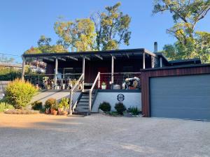 une maison avec une porte de garage et un bâtiment dans l'établissement Arthurs Seat Cottage - Sulla Collina, à Arthurs Seat