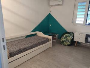 - une chambre dotée d'un lit avec un mur vert dans l'établissement Rêves de rivière- fonctionnel et bien placé, à Le Carbet