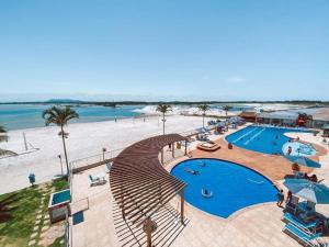 a resort with a swimming pool and a beach at Apartamento, Apart Hotel, 02 Quartos - Arraial do Cabo in Arraial do Cabo