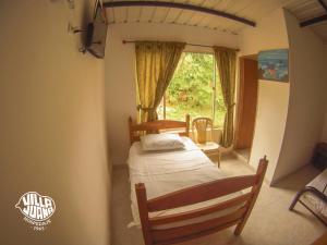 - une chambre avec un lit et une fenêtre dans l'établissement Hospedaje y Cabañas Villa Juana, à Tobia