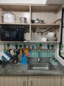 um balcão de cozinha com um lavatório e um micro-ondas em Staycation 2 Bedroom in Urban Deca Home Marilao em Marilao