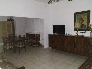 sala de estar con chimenea, mesa y TV en Casa Argenta en Córdoba