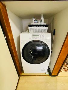 uma máquina de lavar e secar roupa num pequeno quarto em 池袋至近完全貸切一軒家 em Tóquio