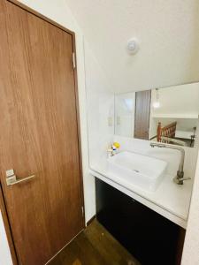 a bathroom with a sink and a wooden door at 新宿直通完全貸切一軒家 in Tokyo