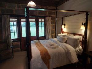 1 dormitorio con 1 cama grande con marco de madera en The Stone House Stay Connect Explore, en Pokolbin
