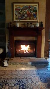 a fireplace in a living room with a fire in it at The Stone House Stay Connect Explore in Pokolbin