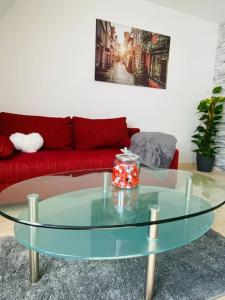 - une table basse en verre dans le salon avec un canapé rouge dans l'établissement UNMITTELBAR am ULMER MÜNSTER - Cozy Apartment, à Ulm