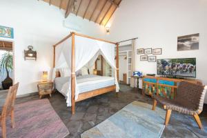 a bedroom with a canopy bed and a desk at Villa Damai Manis in Seminyak