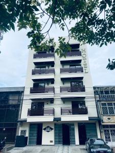 a tall white building with a car parked in front of it at Hotel Boutique Palacete in Bogotá