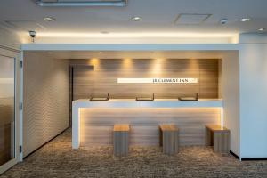 an office lobby with a counter and two benches at JR CLEMENT INN HIMEJI in Himeji