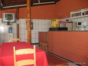 a kitchen with a table with a red table cloth at SITIO ESTANCIA DA LAPA in Sao Jose da Lapa