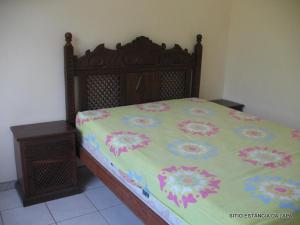 a bedroom with a bed with a floral bedspread at SITIO ESTANCIA DA LAPA in Sao Jose da Lapa