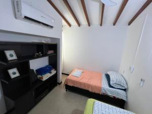 małą sypialnię z łóżkiem i telewizorem w obiekcie Hermoso apartasol en santafe de Antioquia. w mieście Santa Fe de Antioquia