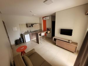 a living room with a couch and a tv and a kitchen at Apartamento 2 quartos no Alta Vista Thermas Resort in Caldas Novas