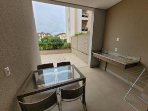 a glass table and chairs in a room with a large window at Apartamento 2 quartos no Alta Vista Thermas Resort in Caldas Novas