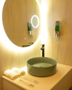 lavabo con espejo redondo encima en Seeya Hotel en Tubigon