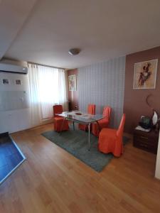 a living room with a table and orange chairs at Apartman Stanimirović in Zaječar
