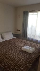 - une chambre avec un lit et 2 serviettes blanches dans l'établissement Alexandra Parklife Deluxe Studio 2, à Alexandra