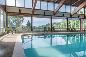 a swimming pool in a building with windows at Muskoka Ski Chalet in Huntsville