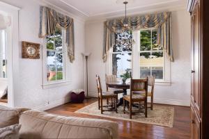 a living room with a table and chairs and windows at Seven Gables Inn on Monterey Bay, A Kirkwood Collection Hotel in Pacific Grove