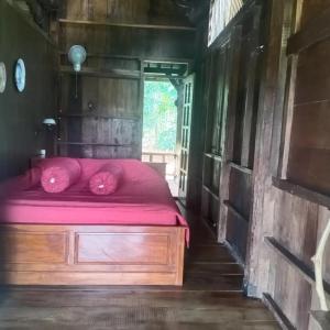 Un dormitorio con una cama con almohadas rosas. en Havana Horses Lodge en Tingkirtengah