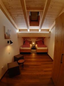 a attic room with two beds and a tv at Ilgerhof Ferienwohnungen in Oberaudorf